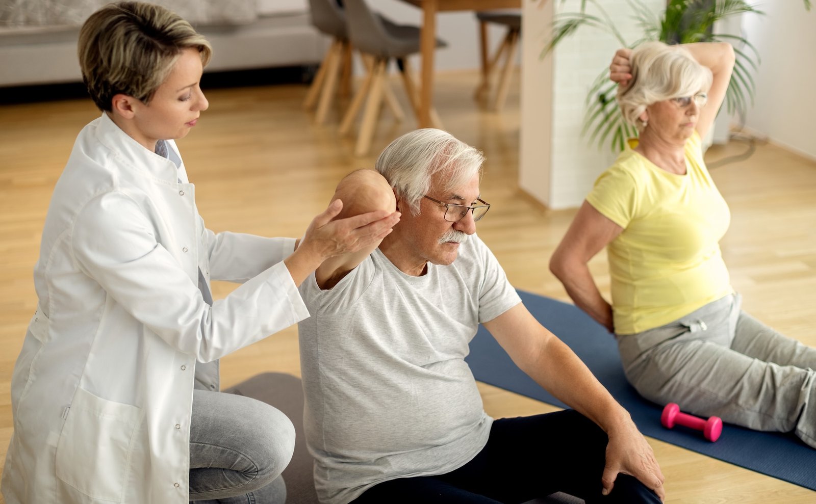 Physical therapist assisting mature couple with exercises at home. Acredia - New Staffing Quality Indicators, What Aged Care Providers Need to Know
